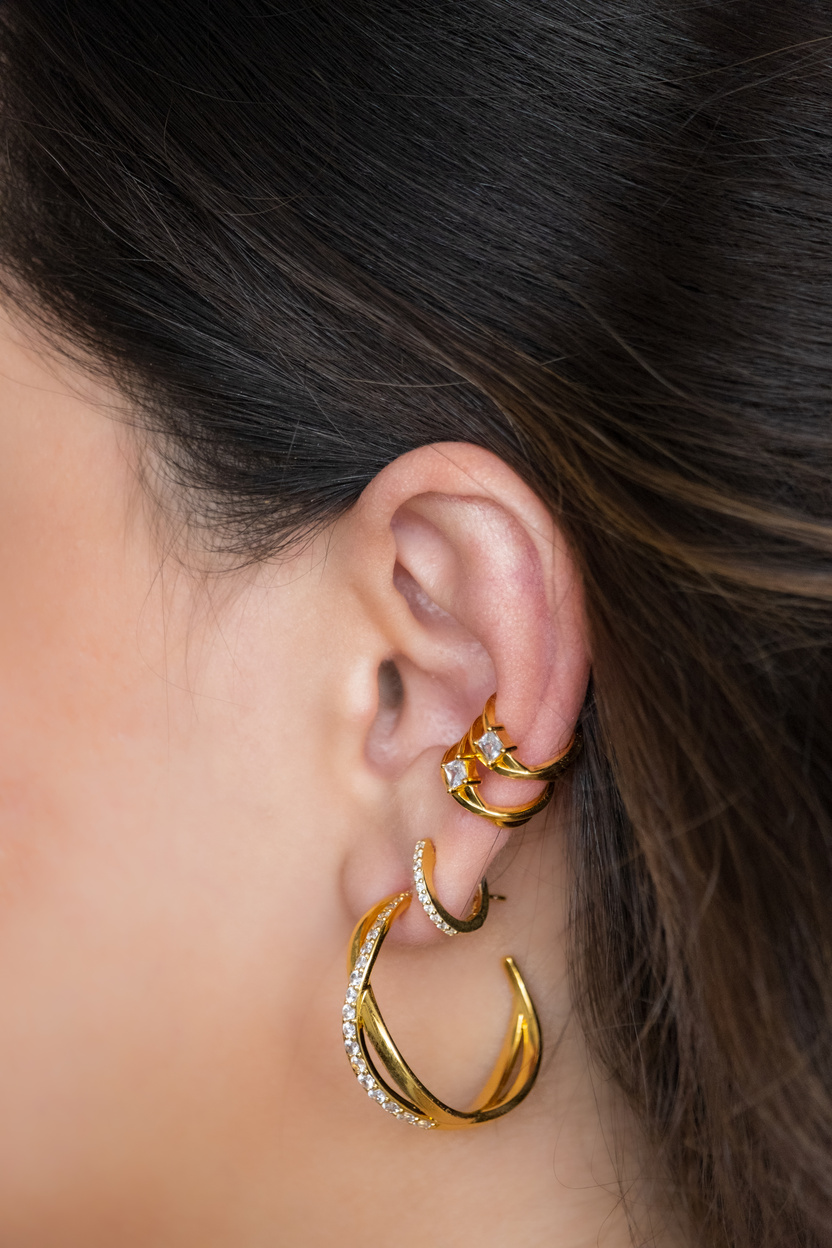 Woman ear with mulriple piercings wearing beautiful earrings wit